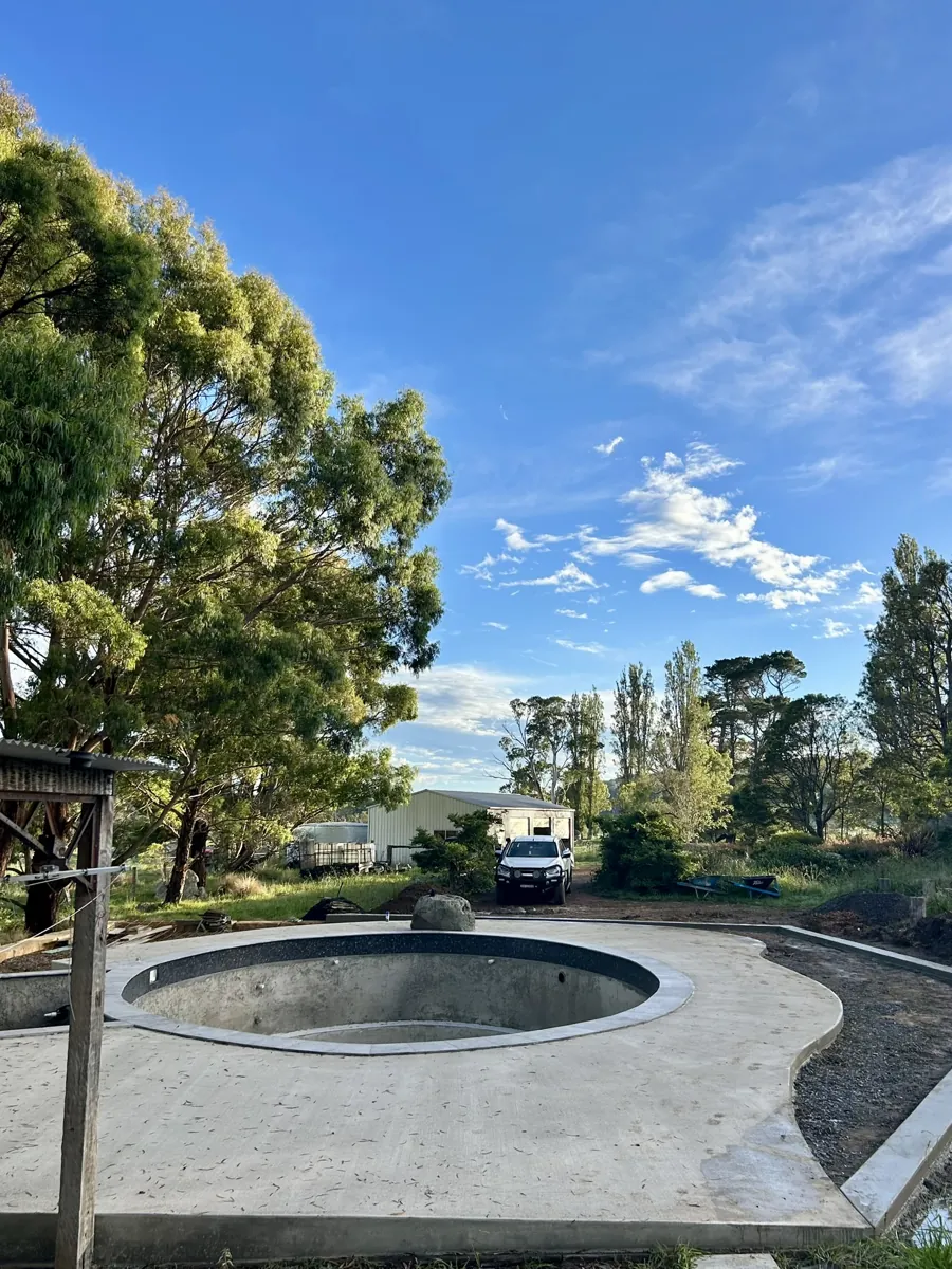 Circular concrete outdoor area around custom pool